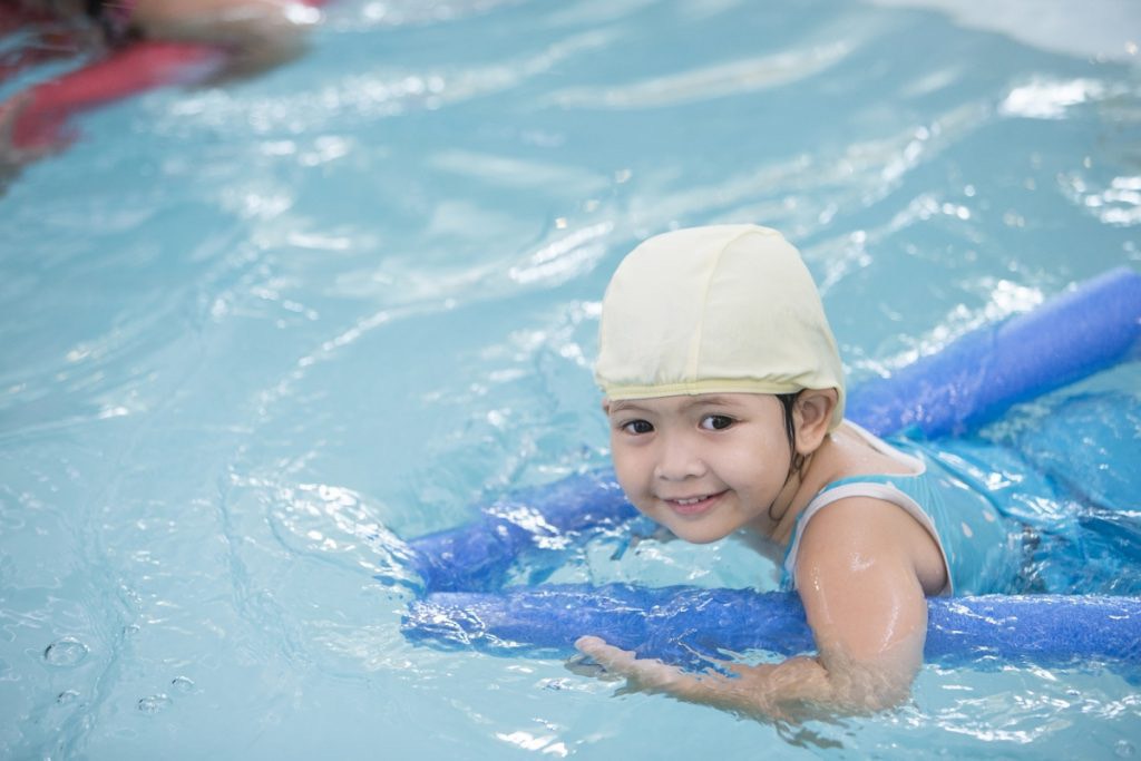 baby swimming with pool noodles